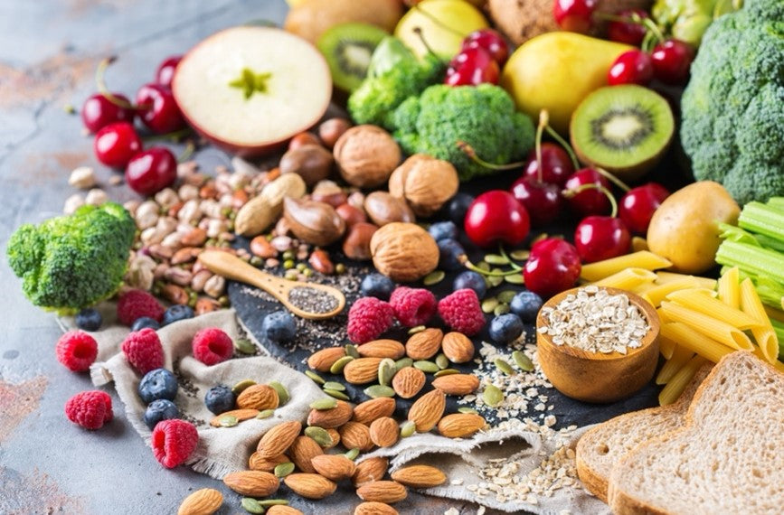 An assortment of fiber-rich and keto-friendly foods, such as fruits, bread, nuts, and vegetables.