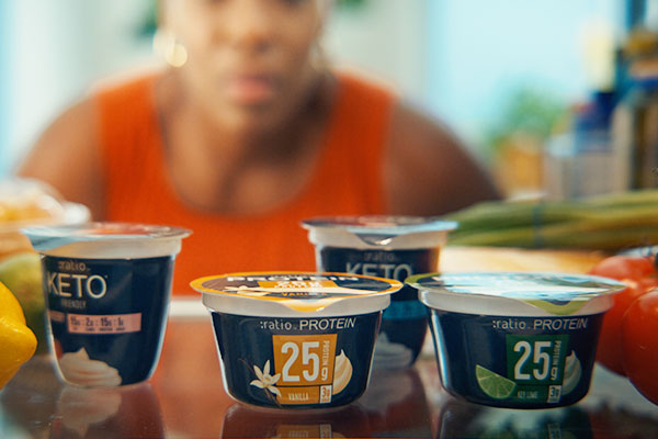 A person looking inside an open refrigerator full of Ratio PROTEIN Dairy Snacks in multiple flavors.