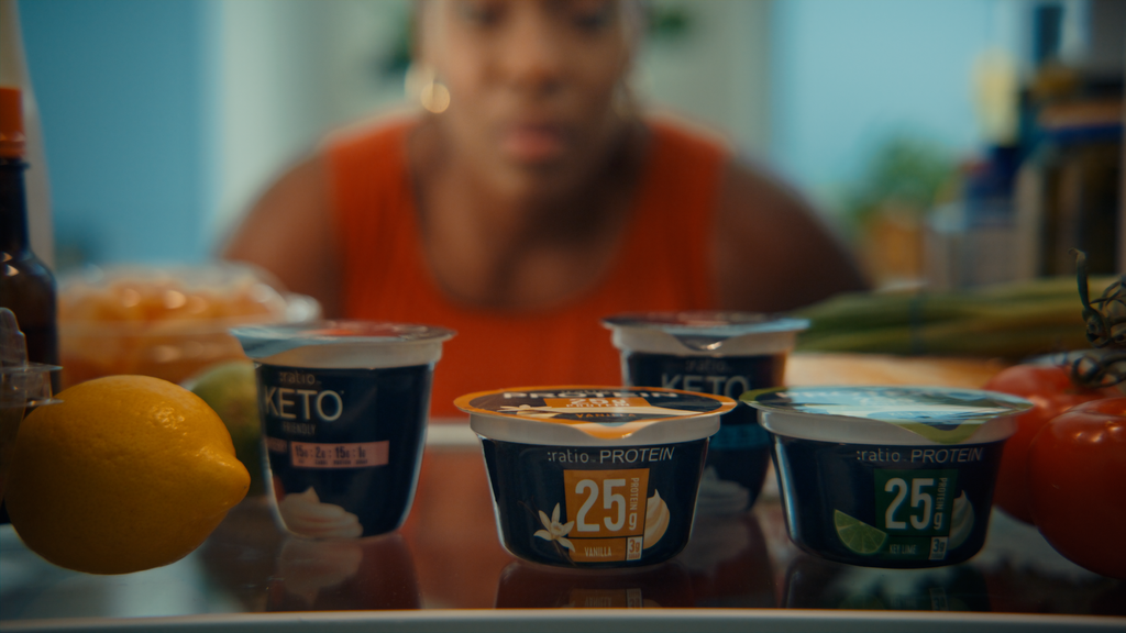 Four different yogurt cups of different flavors and sizes.